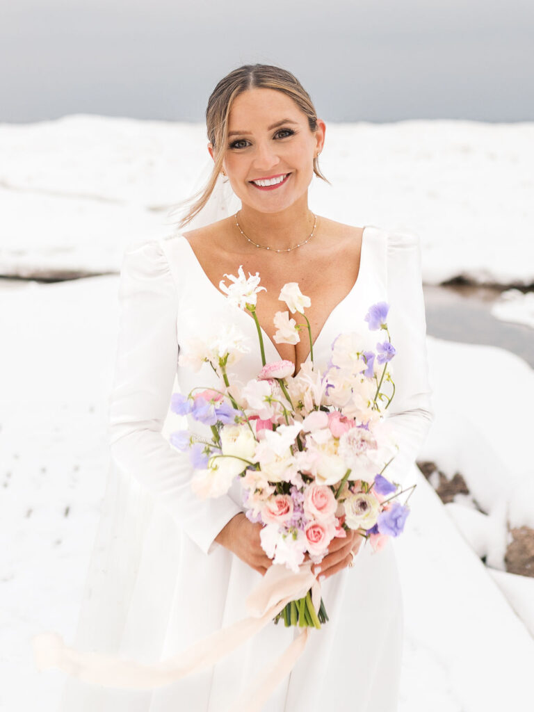 bride and groom romantic portraits in snow Final snowy portrait outside holding hands, winter micro-wedding film shot