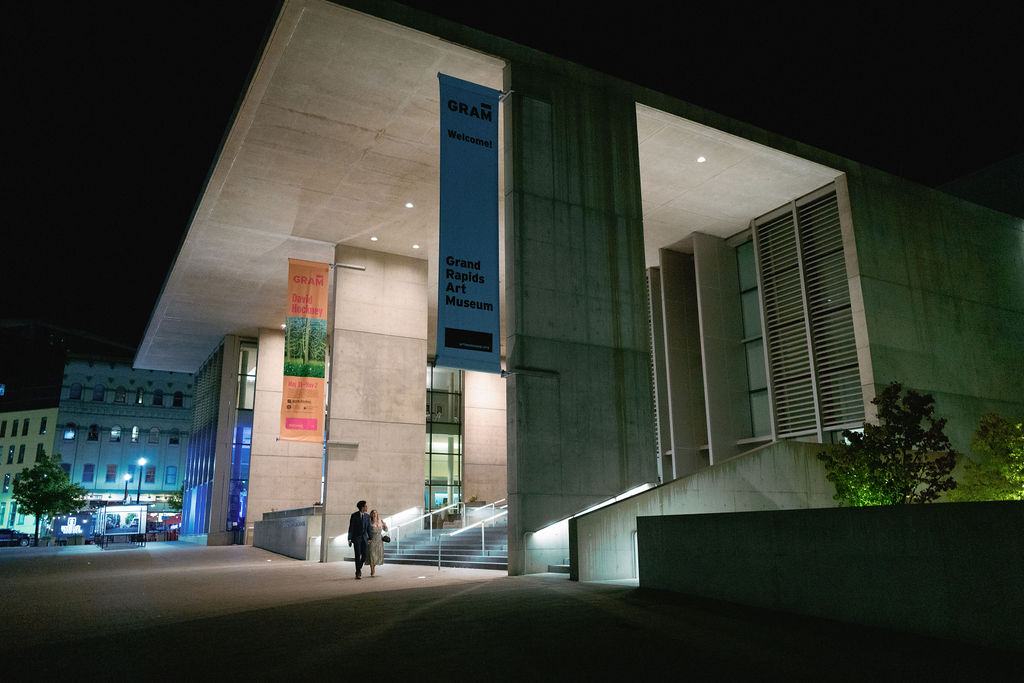 Night portrait outside the Grand Rapids Art Museum with sleek city glow