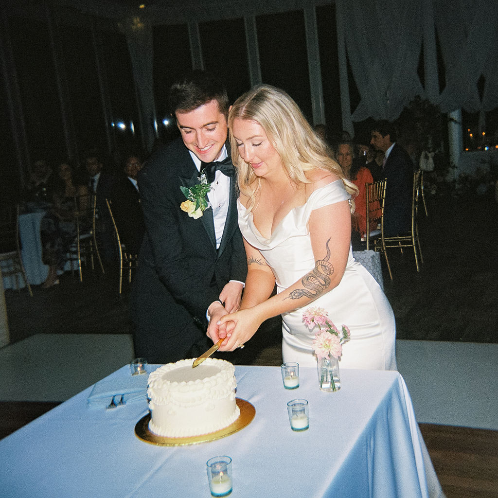 Elegant outdoor reception tablescape with candles and classic florals on film