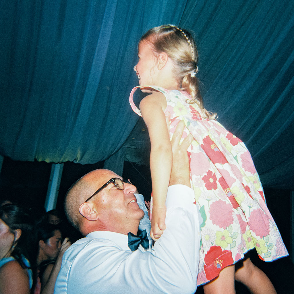Elegant outdoor reception tablescape with candles and classic florals on film