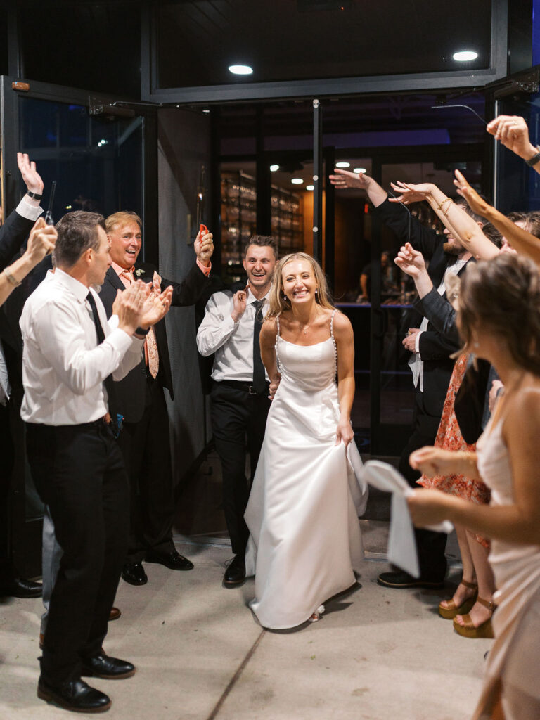 Bride and groom dancing with guests on the rooftop, candid summer celebration