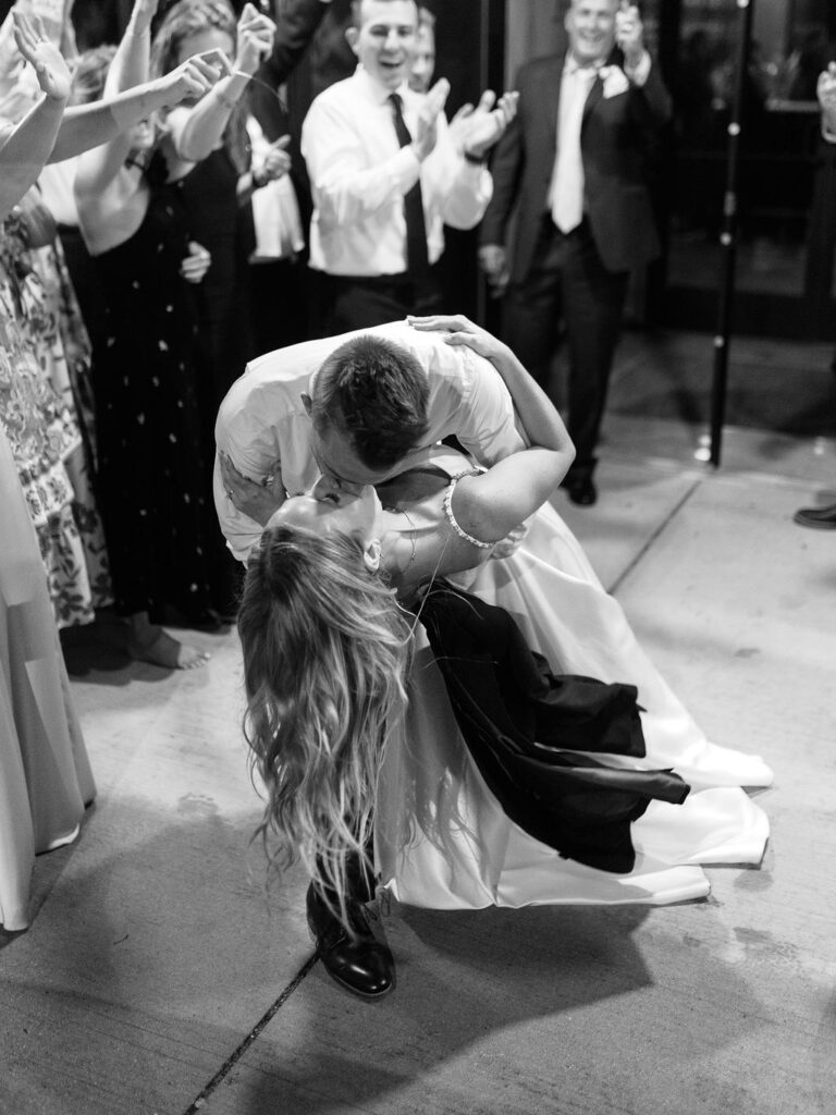 Bride and groom dancing with guests on the rooftop, candid summer celebration
